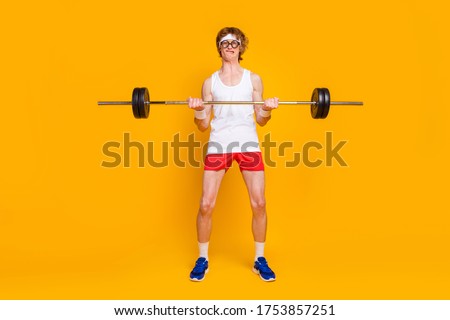 Full length body size view of his he nice attractive weak slim sportive guy lifting heavy barbell individual work out isolated over bright vivid shine vibrant yellow color background