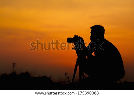 Professional Photographer silhouette at sunset, in Thailand.