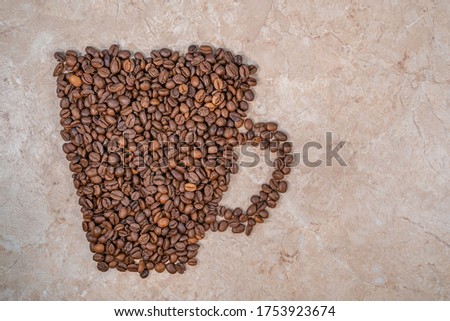 brown coffee beans sprinkled in a cup shape isolate