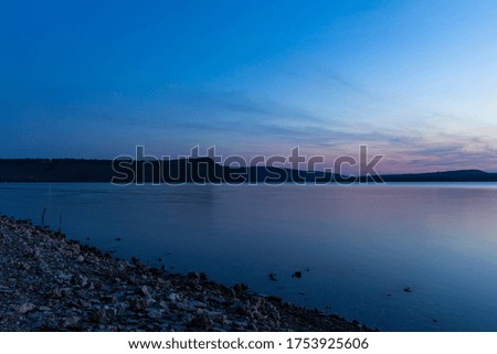 evening landscape of river nature scenic view and hill land background long exposure photography in twilight lighting after sunset 