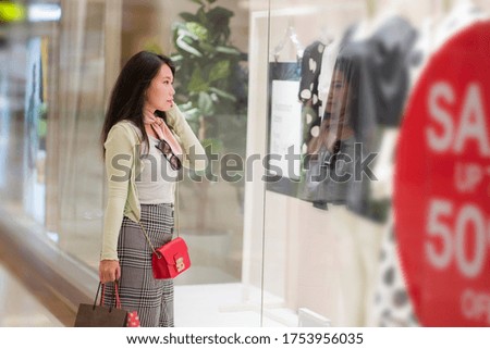 young beautiful and happy Asian buying at shopping mall - young attractive and stylish Chinese woman holding shopping bags at fashion center enjoying sales and discount excited