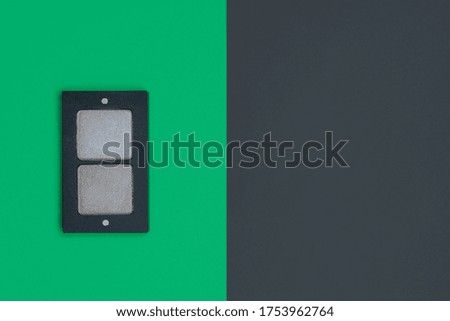 on a green background lies a palette of eye shadow from two shades of gray color. Black background is empty