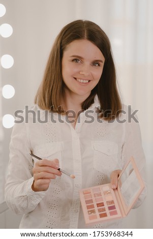 Stock Photo - In the beauty salon doing makeup. Professional makeup artist with palette of shadows