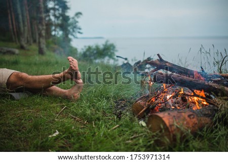 Camping and legs of a man by the fire