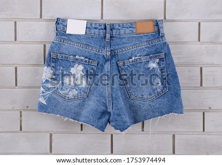 Women's Blue jeans floral , pattern shorts on wall background-back view 


