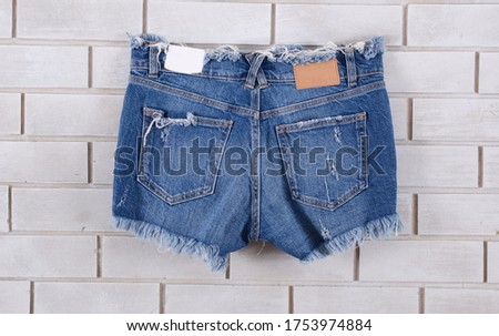 Women's Blue jeans shorts on wall background-back view 

