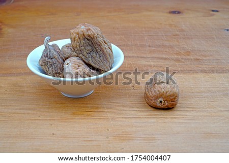 Plateful of Organic Dried persimmon and Spilled Dried persimmon on Wooden Background