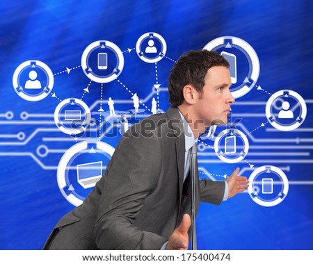 Businessman posing with hands out against white circuit board on blue background