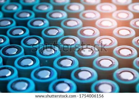 A pack of lithium-ion cells of the 18650 format folded with a positive terminal up. Image with flare effect. Royalty-Free Stock Photo #1754006156