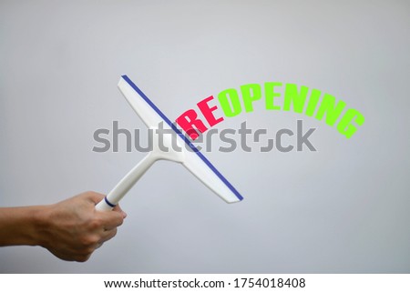 Reopen economy concept after the coronavirus pandemic,The squeegee with tex REOPENING on white background
