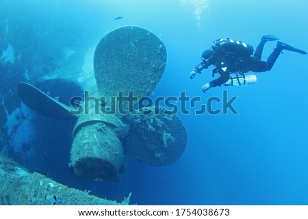 Scuba divers explores propeller of sunken shipwreck Zenobia, Cyprus. Royalty-Free Stock Photo #1754038673