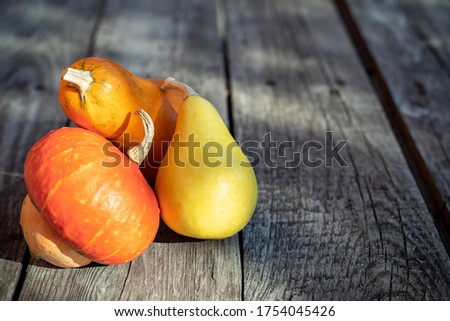 Three decorative pumpkins on an old wooden table for design on the theme of autumn, harvest.