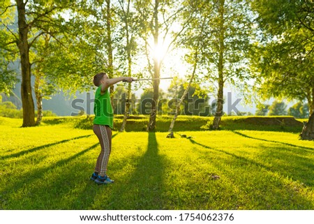 young boy playing in badminton at sunset