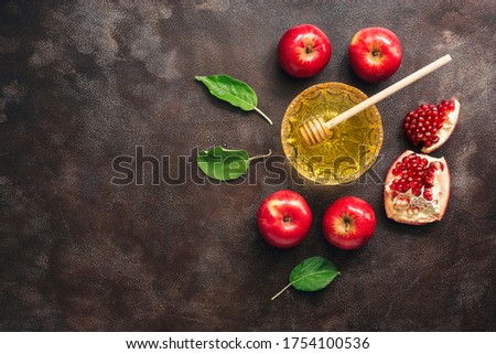 Apples, pomegranate and honey on a dark rustic background. Jewish New Year - Rosh Hashanah. Traditional Jewish food. Top view, flat lay,copy space