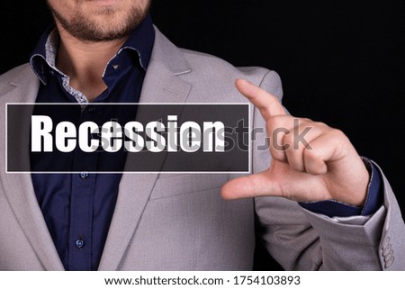 A businessman holding a business icon with the text RECESSION written on it.