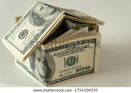 Mini house of dollars banknote. Concept of Investment property, Mortgage concept. Investment risk and uncertainty in the real estate housing market. Royalty-Free Stock Photo #1754104310