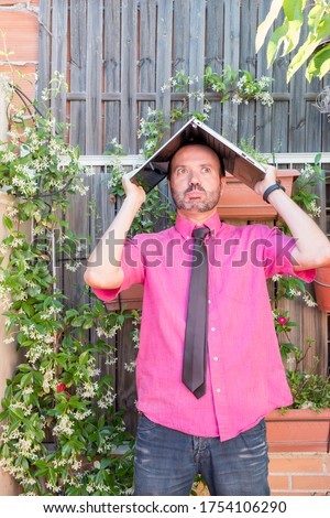 Middle-aged man teleworking in his backyard fuchsia shirt with tie and dark jeans