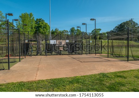 Empty and vacant batting cages at a baseball softball field in a park closed due to the Covid-19 pandemic in early springtime Royalty-Free Stock Photo #1754113055