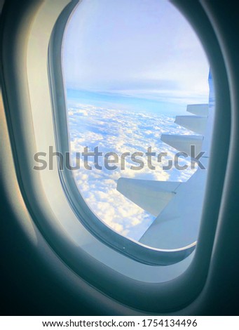 Airplane window picture wing and clouds