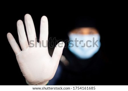 Stop coronavirus. A young Asian woman wearing a face mask and medical rubber gloves. Protest and Focus shifted photo.