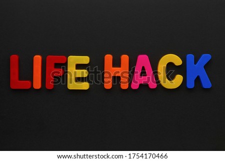 Text made in multicolored magnetic letters. LIFE HACK. Black background