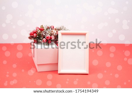Christmas or winter composition. Frame and gift box. Christmas decorations. Christmas wreath. Red background. Christmas, new year concept. copyspace