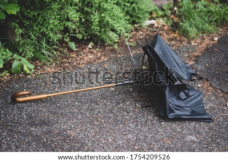 Broken umbrella thrown away and lying on the street. Royalty-Free Stock Photo #1754209526