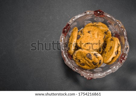 Shortbread with small pieces of black chocolate in transparent glass cup with red inserts