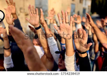 Close-up of large group of activists with raised arms on public demonstrations. Royalty-Free Stock Photo #1754238419