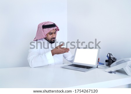 Saudi Arab Man showing laptop display with some message while working