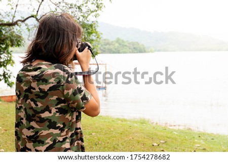 Asian female photographer tourists standing to take pictures of nature by the river. At Khuan Khe Ree Then, Chanthaburi Thailand,