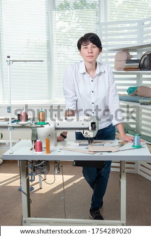 seamstress girl is at the workplace behind the sewing machine