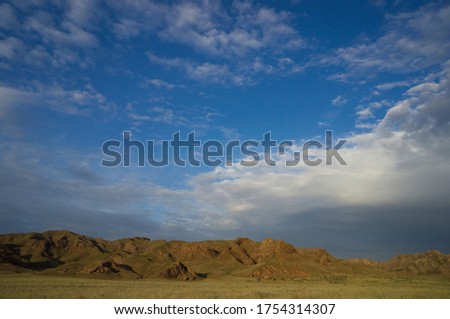 Landscape in the steppe, Prairie. Landscape in the river valley, mountains. An epic moment in nature, rain clouds are approaching the dried steppe. It will rain soon.