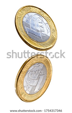 Falling one brazilian real coins isolated on white background