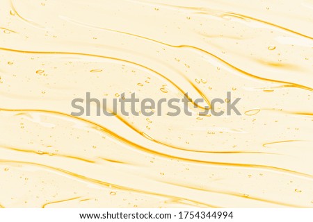 Oil serum texture. Yellow vitamin C, vitamin E liquid gel. Transparent cosmetic cream with bubbles smear smudge. Beauty skincare product macro top view Royalty-Free Stock Photo #1754344994