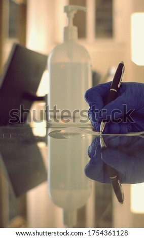 Person sign the bill with surgical gloves during corona virus 2020
