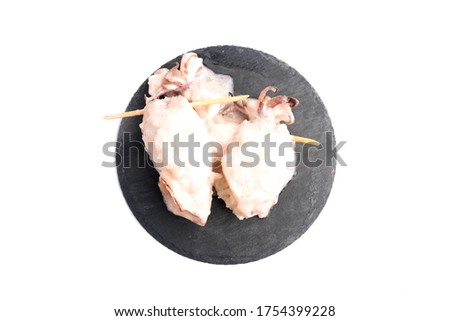 A flatlay and high key picture of "ketupat sotong" on slate table white background. Glutinous rice stuffed in squid that is famous East Coast of Malaysia.