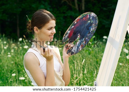 An artist with a palette in her hand and a single is an art of paint