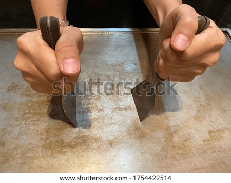 Hand of man cooking in Japanese teppanyaki restaurant