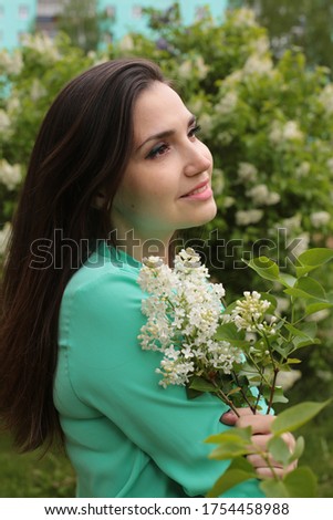 beautiful young woman with brown hair brown in a good mood positive emotions joy of spring morning in flowering trees