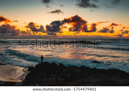 The sunset view of the coast in Pebble beach, with back lit person in front.