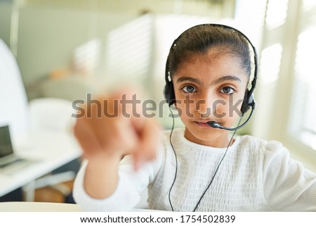 African girl with headset is working in the call center for direct marketing