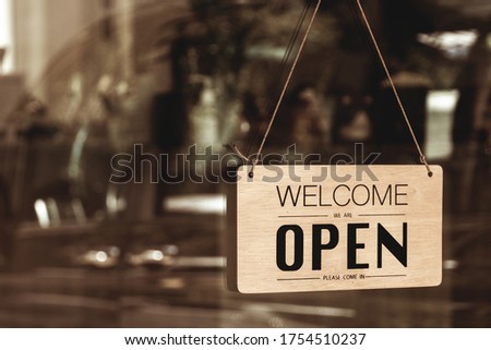 Text sign that says ‘Open’ in cafe or restaurant hang on door at entrance. Effect filter