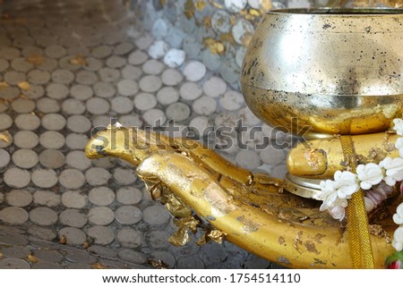 Gold leafing on the Buddha statues in Wat Ban Tung Khlet Prachuap Khiri Khan, Thailand