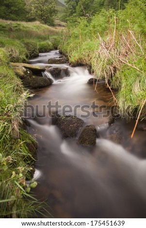 long exposure of flowing water in green countryside in the peak district