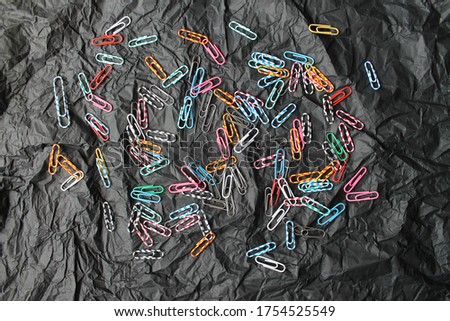Color paperclips on black background