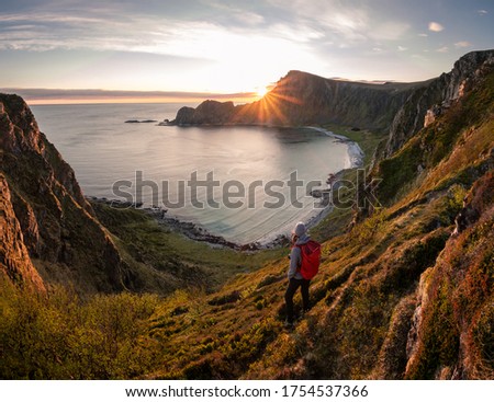 A woman hiking during midnight sun. Active vacation in Norway. Located on Andøya island in Vesterålen north of Norway. Sunset and backpack girl. Royalty-Free Stock Photo #1754537366