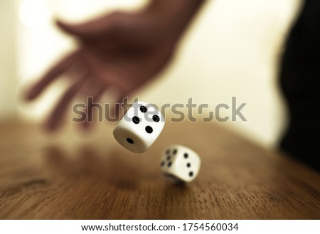 rolling dices on a wooden table Royalty-Free Stock Photo #1754560034
