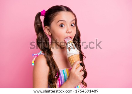 Closeup photo of beautiful little lady two cute long tails hold big cone ice cream can't wait lick tongue try vanilla taste wear summer dress isolated pastel pink color background