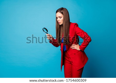 Profile photo of attractive business lady holding enlarge loupe searching piece of evidence wear luxury trend red suit blazer pants blouse shirt isolated blue color background